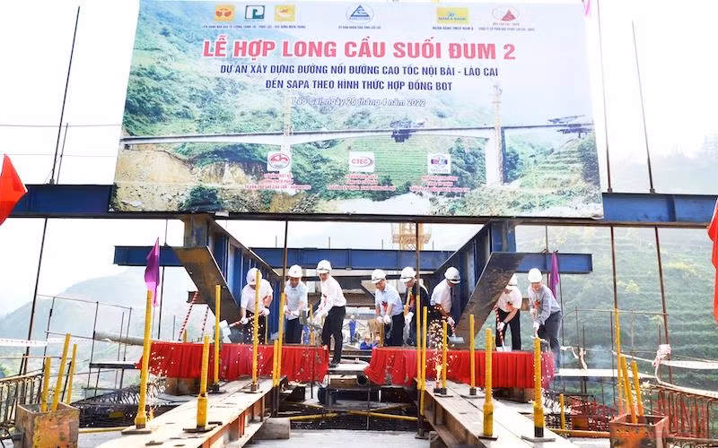 Lãnh đạo tỉnh Lào Cai, chủ đầu tư và đơn vị thi công thực hiện nghi thức hợp long cầu Suối Đum 2 trên cao tốc Lào Cai-Sa Pa.