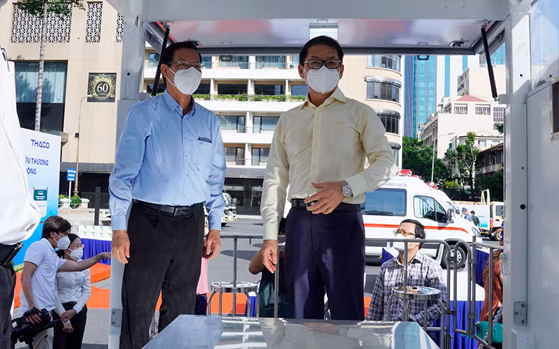 Ông Trần Bá Dương (bên phải) giới thiệu về cơ chế vận hành của xe tiêm chủng cơ động.