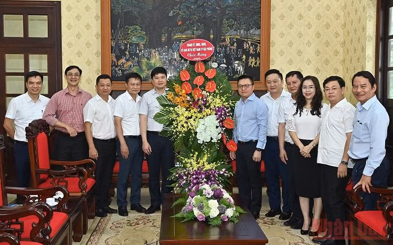 Tổng Biên tập Lê Quốc Minh cùng lãnh đạo Báo Nhân Dân đón nhận lẵng hoa chúc mừng của đoàn đại biểu Thành ủy, HĐND, UBND, Ủy ban MTTQ Việt Nam TP Hải Phòng. (Ảnh: DUY LINH)
