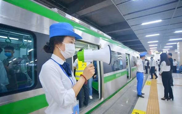 Nhân viên tàu điện Cát Linh-Hà Đông hướng dẫn hành khách mua vé và bảo đảm trật tự trước khi lên tàu.