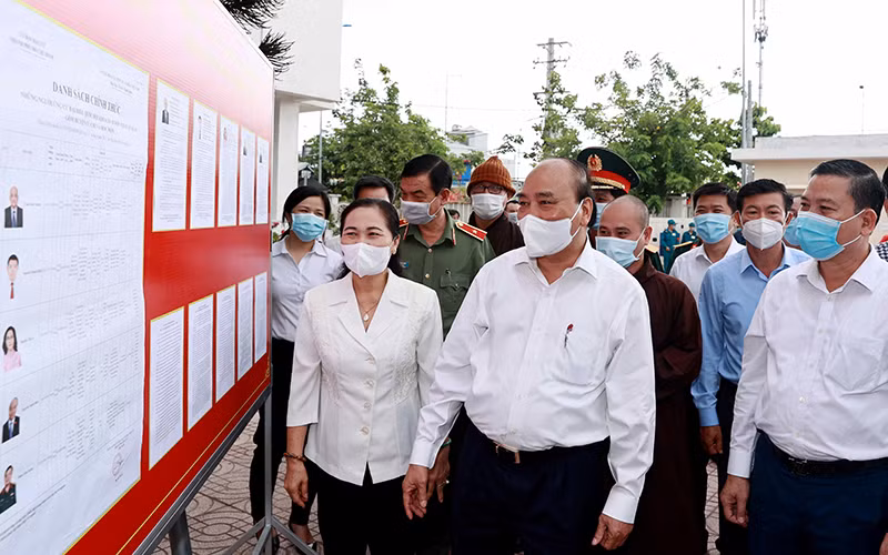 Chủ tịch nước Nguyễn Xuân Phúc xem danh sách các ứng cử viên đại biểu Quốc hội niêm yết tại xã Trung Chánh, huyện Hóc Môn. Ảnh: Thống Nhất (TTXVN)