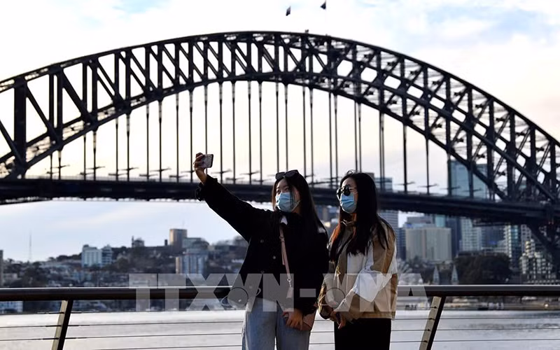 Du khách chụp ảnh tại khu vực Cầu Cảng Sydney, Australia. (Ảnh: AFP/TTXVN)