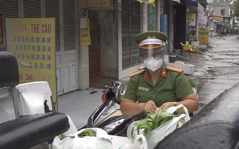 Nữ cảnh sát khu vực Đinh Thị Diệu Hạnh đi chợ giúp dân trong lúc thực hiện giãn cách xã hội.