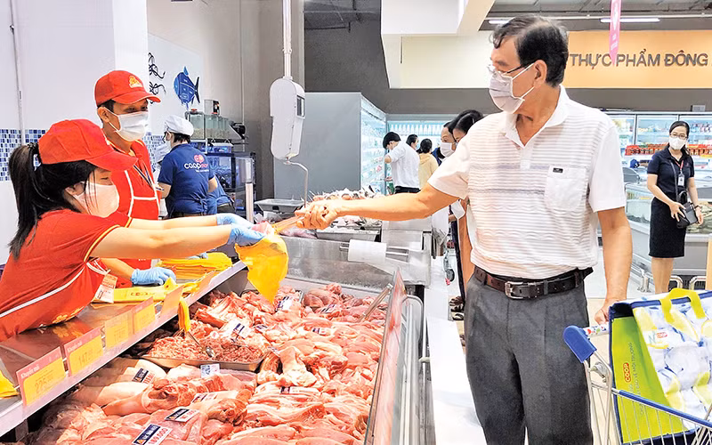 Người tiêu dùng mua thịt heo ở một siêu thị Co.opmart.Ảnh: CTV