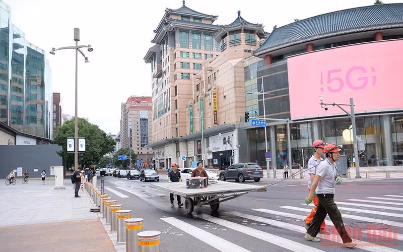 Người lao động không đeo khẩu trang đi qua một ngã tư. (Ảnh: VI SA)