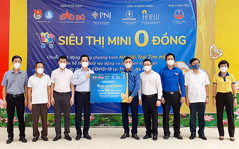 Đại diện Ban Tổ chức “Siêu thị mini 0 đồng” trao 800 phiếu mua hàng tặng đại diện chính quyền quận Hoàn Kiếm.