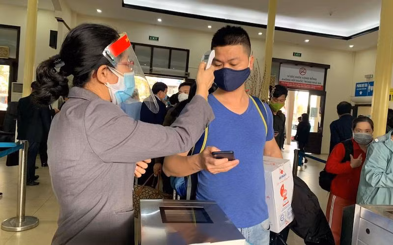 Đo thân nhiệt cho hành khách trước khi lên tàu. (Ảnh: mt.gov.vn)