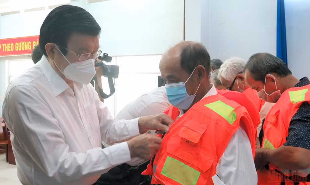 Nguyên Chủ tịch nước Trương Tấn Sang trao áo phao cứu sinh cho ngư dân.
