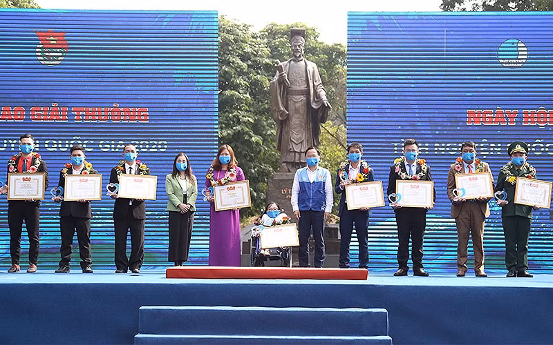 Đồng chí Nguyễn Anh Tuấn (áo xanh, đứng giữa trong ảnh) trao Bằng khen tặng các tình nguyện viên có cống hiến xuất sắc trong năm vừa qua.