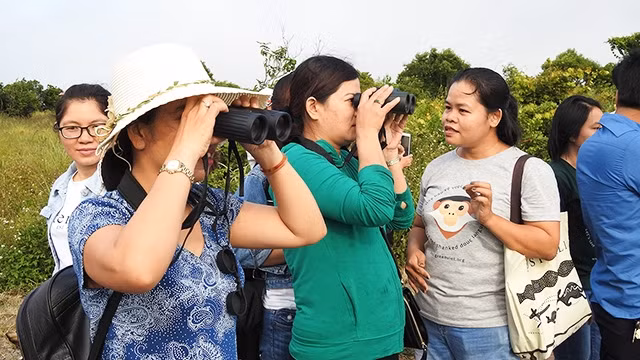 Chị Lê Thị Trang (bên phải) hướng dẫn mọi người quan sát Voọc qua ống nhòm.