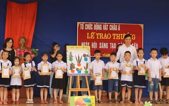 Đại diện Phòng giáo dục huyện Phúc Thọ và Tổ chức Động vật Châu Á cùng trao giải nhì cho một tổ dự thi.