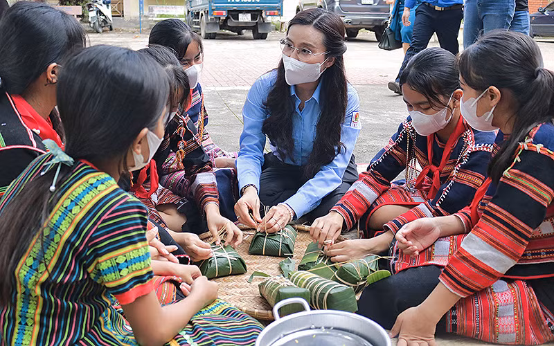 Đồng chí Nguyễn Phạm Duy Trang cùng thiếu nhi dân tộc thiểu số gói bánh chưng, bánh tét tại chương trình “Xuân sẻ chia-Tết yêu thương”.