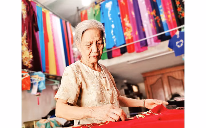 Dù đã hơn 80 tuổi, bà Quyến vẫn gắn bó với nghề may áo dài truyền thống.
