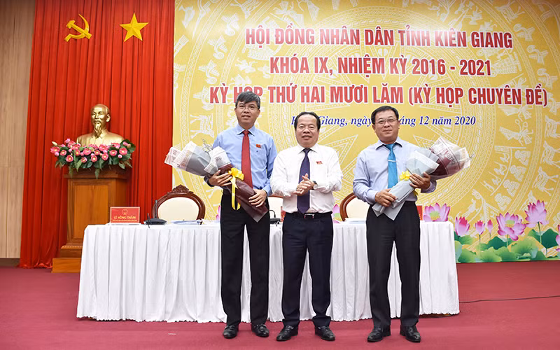 Ông Nguyễn Lưu Trung (trái) nhận hoa chúc mừng của Thường trực HĐND tỉnh Kiên Giang.