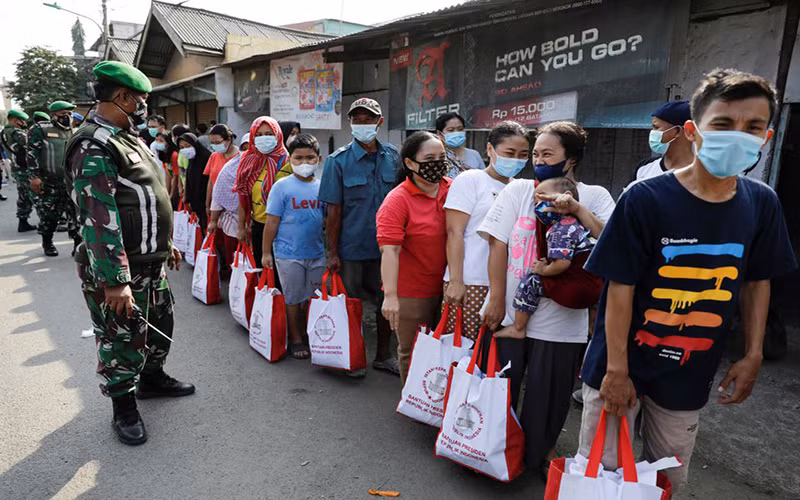 Người dân đeo khẩu trang trong lúc xếp hàng nhận hỗ trợ tain thủ đô Jakarta, ngày 16/7/2021. (Ảnh: Reuters)
