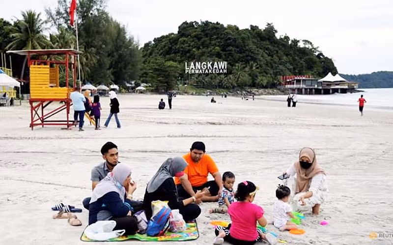 Du khách nghỉ ngơi trên bãi biển ở Langkawi theo mô hình "bong bóng du lịch" (Ảnh: REUTERS)