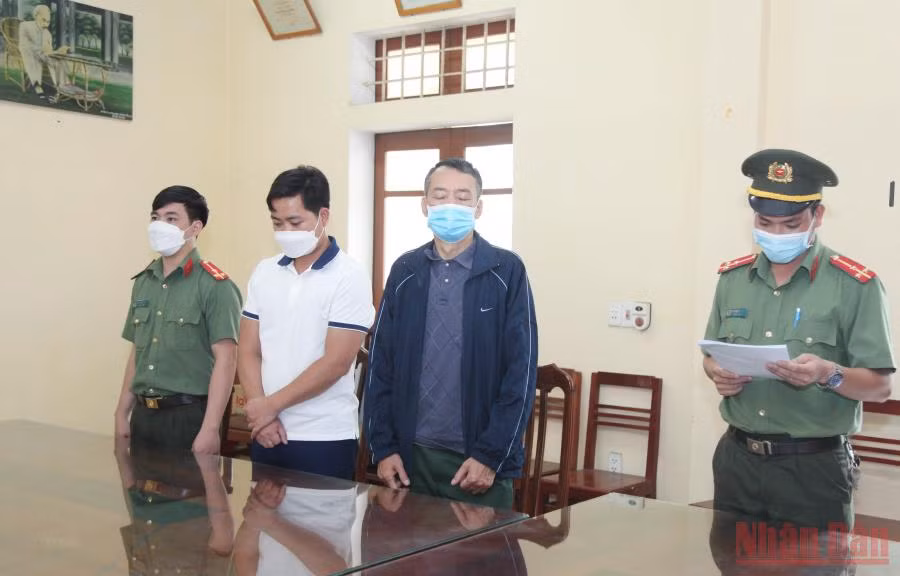 Cơ quan An ninh điều tra đọc lệnh bắt tạm giam đối tượng Khánh và An. (Ảnh: TTXVN)