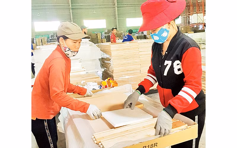 Sản xuất cánh tủ bếp và tủ nhà tắm tại Công ty gỗ Tiến Đạt. Ảnh: Mai Hương