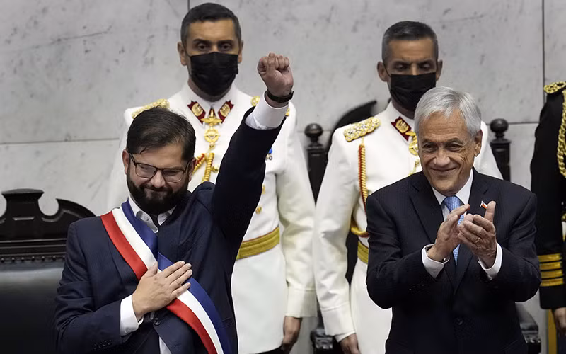 Tổng thống Gabriel Boric (bên trái) trong lễ nhậm chức. (Ảnh EL PAIS)