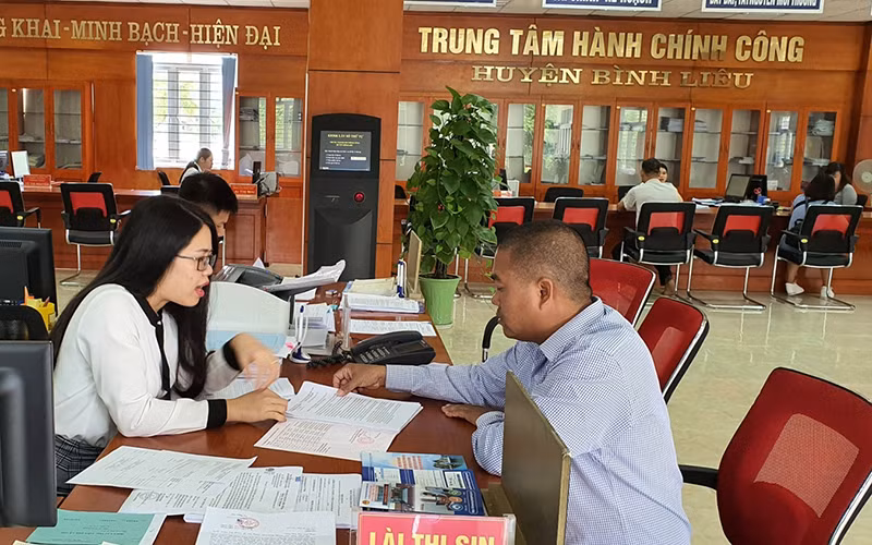 Cán bộ Trung tâm Hành chính công huyện Bình Liêu hướng dẫn người dân làm thủ tục.