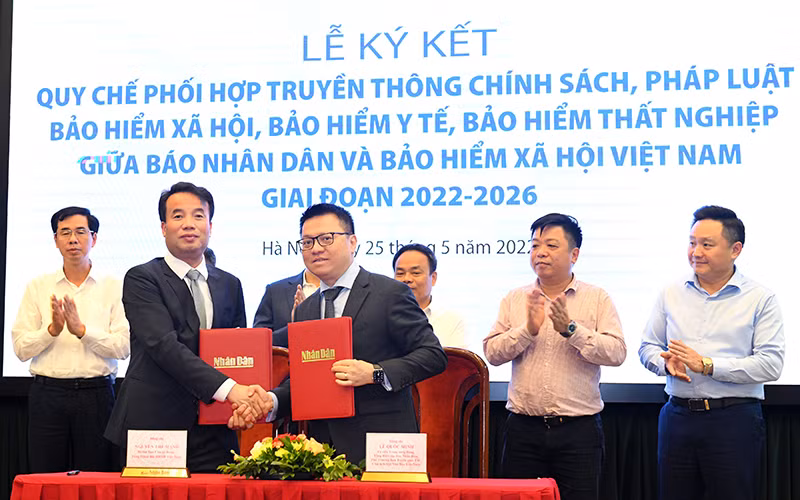 Tổng Biên tập Báo Nhân Dân Lê Quốc Minh và Tổng Giám đốc Bảo hiểm xã hội Việt Nam Nguyễn Thế Mạnh tại Lễ ký kết. (Ảnh: Thành Đạt)