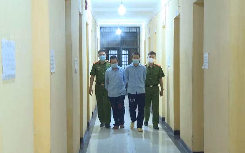 Lực lượng Công an dẫn giải hai đối tượng cầm đầu sàn tiền ảo.