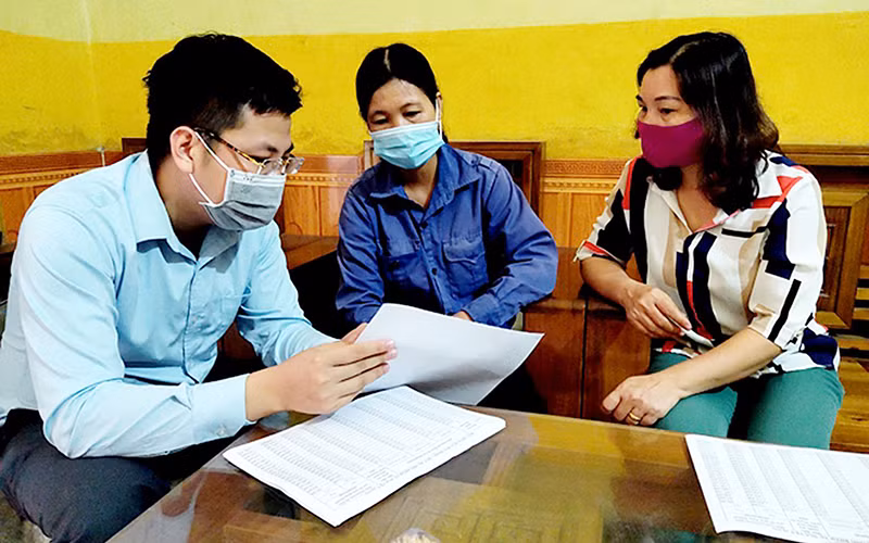Cán bộ Bảo hiểm xã hội tỉnh Yên Bái hướng dẫn người lao động cài đặt ứng dụng VssID. Ảnh: HỒNG DUYÊN 