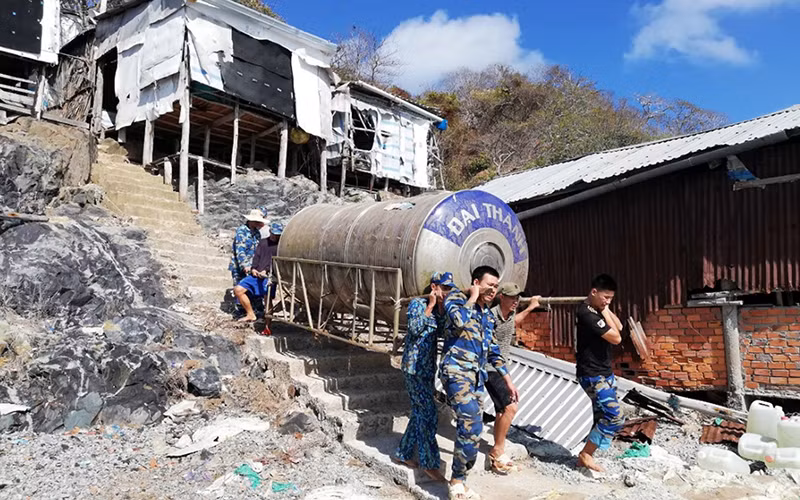 Cán bộ, chiến sĩ Trạm ra-đa 615 (Tiểu đoàn 551, Vùng 5 Hải quân) giúp người dân chuyển téc nước sinh hoạt.