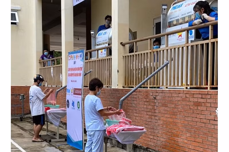 Người dân lấy gạo từ ATM gạo miễn phí đặt tại quận 7.