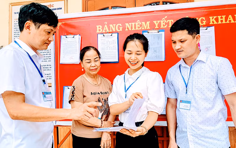 Lãnh đạo UBND thị trấn Trường Sơn, huyện An Lão (Hải Phòng) hướng dẫn giải quyết hồ sơ, thủ tục cho người dân tại bộ phận một cửa.
