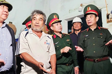 Đại tướng Phan Văn Giang (bìa phải) thăm hỏi, động viên người dân bị thiệt hại bởi mưa lũ tại Gia Lai.