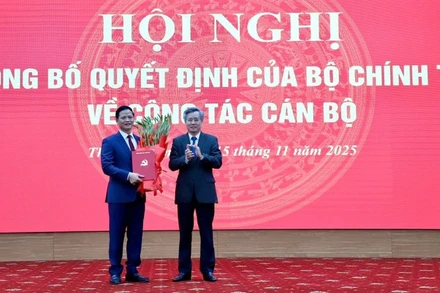 Đồng chí Nguyễn Quang Dương, Phó Trưởng ban Tổ chức Trung ương (bên phải) trao quyết định và tặng hoa chúc mừng đồng chí Vương Quốc Tuấn. (Ảnh: TUẤN SƠN)