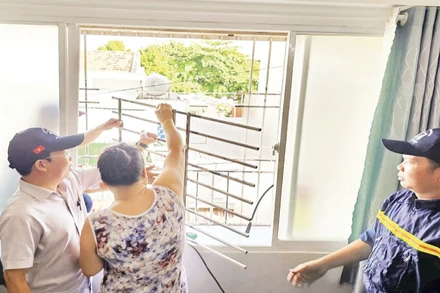 Cán bộ cơ quan chức năng phường Bình Quới thực hiện tháo gỡ “chuồng cọp” tại một hộ dân ở chung cư Thanh Đa.