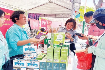 Người dân mua sắm tại các gian hàng trong hội chợ. (Ảnh XUÂN TRƯỜNG)