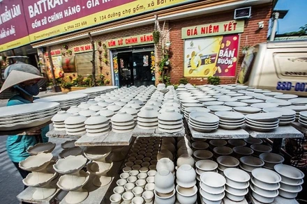 Người dân làng gốm Bát Tràng (Hà Nội) vận chuyển sản phẩm gốm trên đường là một hình ảnh rất quen thuộc của du khách khi tới tham quan. (Ảnh: TTXVN)