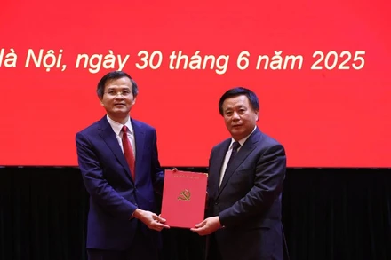 Đồng chí Nguyễn Xuân Thắng, Ủy viên Bộ Chính trị, Giám đốc Học viện Chính trị quốc gia Hồ Chí Minh, Chủ tịch Hội đồng Lý luận Trung ương trao quyết định của Bộ Chính trị về công tác cán bộ cho đồng chí Đoàn Minh Huấn.