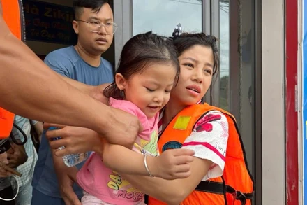 Hỗ trợ người dân ở ngõ 141, đường Bắc Nam đến nơi an toàn. (Ảnh: TUẤN SƠN)