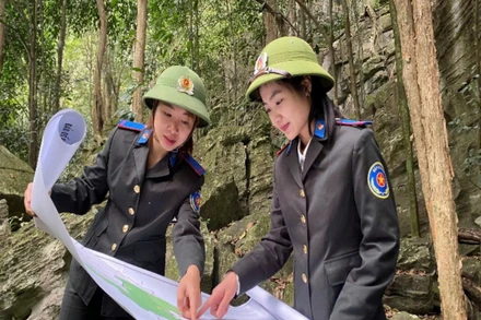 Cán bộ chuyên trách bảo vệ rừng Mùng Thị Hoài (bên phải) cùng đồng đội tuần rừng Nam Xuân Lạc. (Ảnh: TUẤN SƠN).