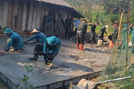 Công an và dân quân tự vệ hỗ trợ đổ bê tông nền nhà cho hộ nghèo ở xã Hiệp Lực. (Ảnh: THÀNH TÂM)