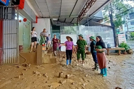 Lãnh đạo phường Đức Xuân kiểm tra, chỉ đạo các lực lượng hỗ trợ người dân khắc phục hậu quả ngập úng. (Ảnh: PHƯƠNG THẢO)