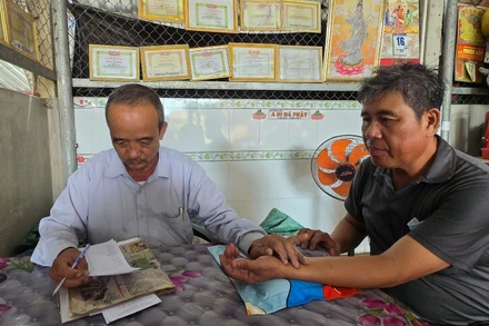 Lương y Nguyễn Văn Chiến chẩn mạch cho người bệnh.