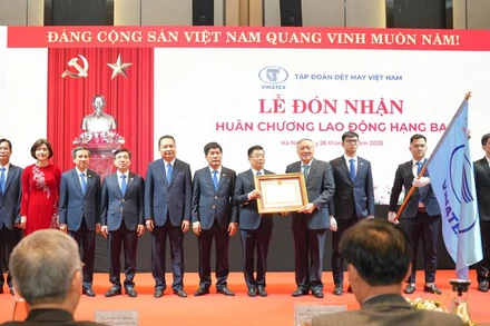 Phó Thủ tướng Thường trực Chính phủ Nguyễn Hòa Bình trao Huân chương Lao động hạng Ba cho Tập đoàn Dệt may Việt Nam. (Ảnh: PV)