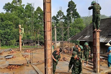 Chiến sĩ Trung đoàn 750 giúp xây nhà mới cho hộ người có công. (Ảnh: TUẤN SƠN).