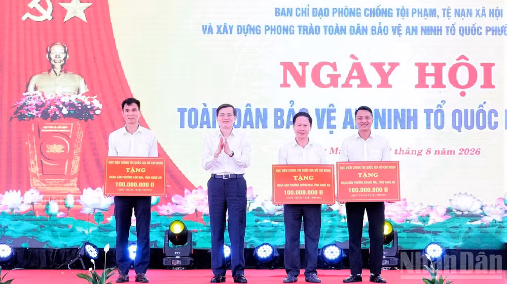 Đồng chí Đoàn Minh Huấn, Ủy viên Bộ Chính trị, Giám đốc Học viện Chính trị quốc gia Hồ Chí Minh tặng quà cho nhân dân các phường: Hoàng Mai, Tân Mai, Quỳnh Mai (Nghệ An). (Ảnh: PT)