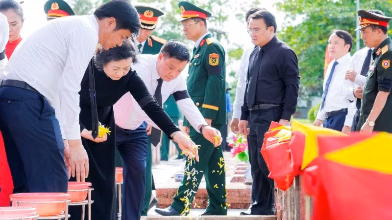 Các đại biểu thực hiện nghi lễ rải hoa ở các phần mộ liệt sĩ.
