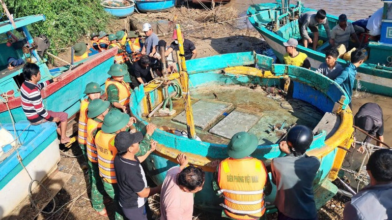 Bộ đội biên phòng hỗ trợ ngư dân kéo tàu lên.