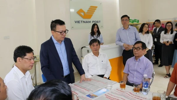 Tổng Biên tập Báo Nhân Dân Lê Quốc Minh trao đổi với người dân địa phương về ý nghĩa của phụ trương công bố dự thảo các văn kiện trình Đại hội XIV do Báo Nhân Dân phát hành.