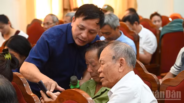 Cán bộ Trung tâm Khoa học, Công nghệ và Chuyển đổi số Hà Tĩnh hướng dẫn người dân cài đặt và sử dụng phần mềm i-HaTinh. (Ảnh: NGÔ TUẤN)