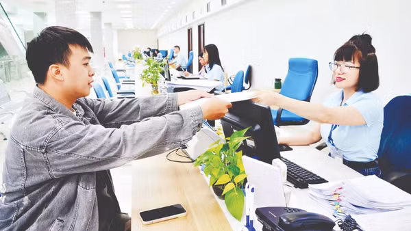 Cán bộ Trung tâm Phục vụ hành chính công tỉnh Quảng Ninh tiếp nhận, xử lý hồ sơ của công dân. (Ảnh THANH HOA)