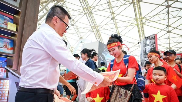 Tổng Biên tập Báo Nhân Dân Lê Quốc Minh phát phụ san đặc biệt của Báo Nhân Dân tới bạn đọc trẻ tại Triển lãm “80 năm Hành trình Độc lập - Tự do- Hạnh phúc”. (Ảnh: THÀNH ĐẠT)